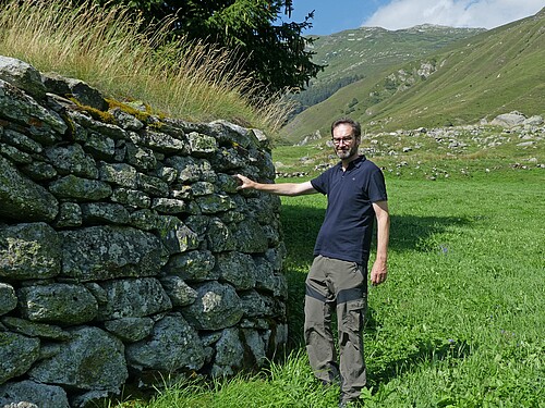 Diese Trockenmauer schützt den Weiler Steinbergen bei Realp (UR); im Bild der Urner Denkmalpfleger Thomas Brunner.