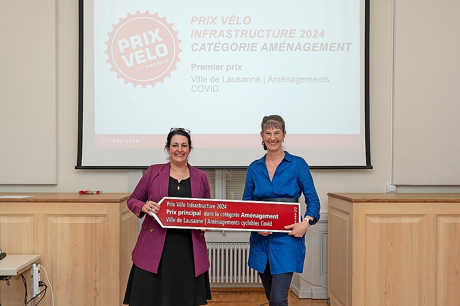 Die für Mobilität zuständige Stadträtin von Lausanne, Florence Germond (rechts), erhält an der Preisverleihung den Prix Velo Infrastruktur 2024 von der Vizepräsidentin von Pro Velo Schweiz, Delphine Klopfenstein.